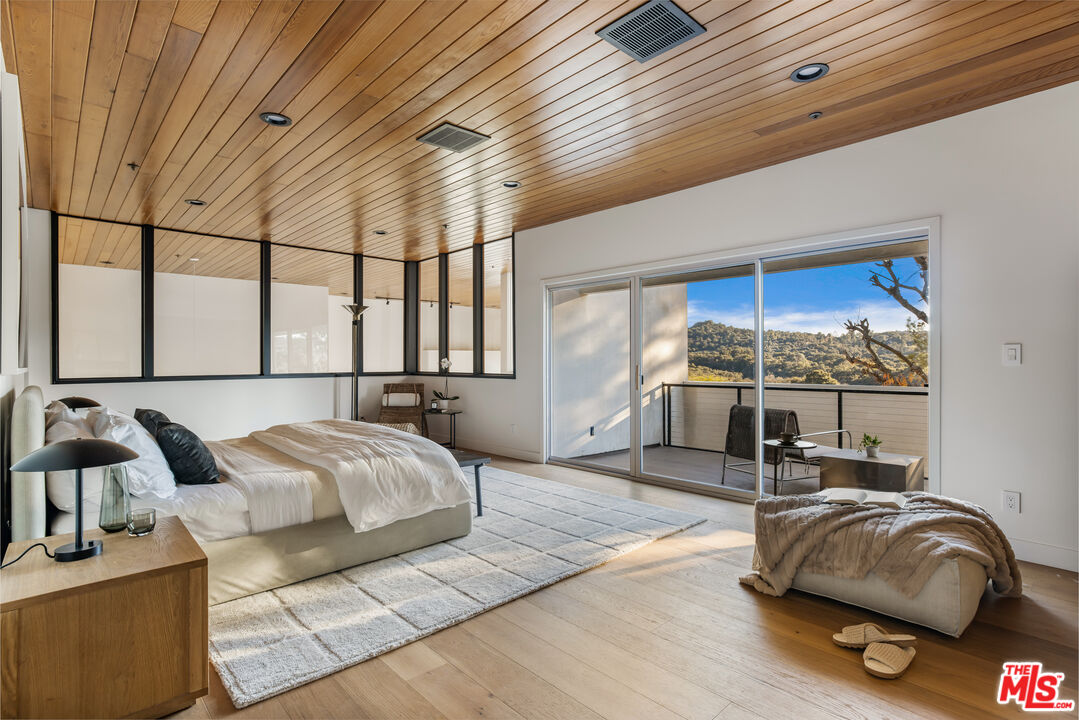 20711 Hillside Drive Topanga, CA 90290 - Photo 18 of 41 a bedroom with furniture and a large window
