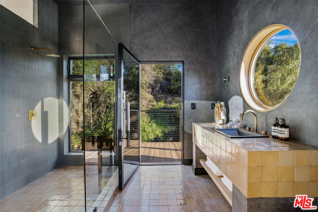 20711 Hillside Drive Topanga, CA 90290 - Photo 30 of 41 a bathroom with a granite countertop sink and a mirror