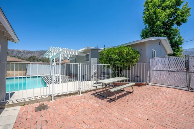 a view of backyard with wooden fence and trees