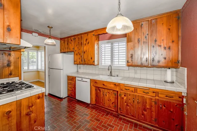 a kitchen with stainless steel appliances granite countertop a stove a sink dishwasher and a refrigerator with wooden floor