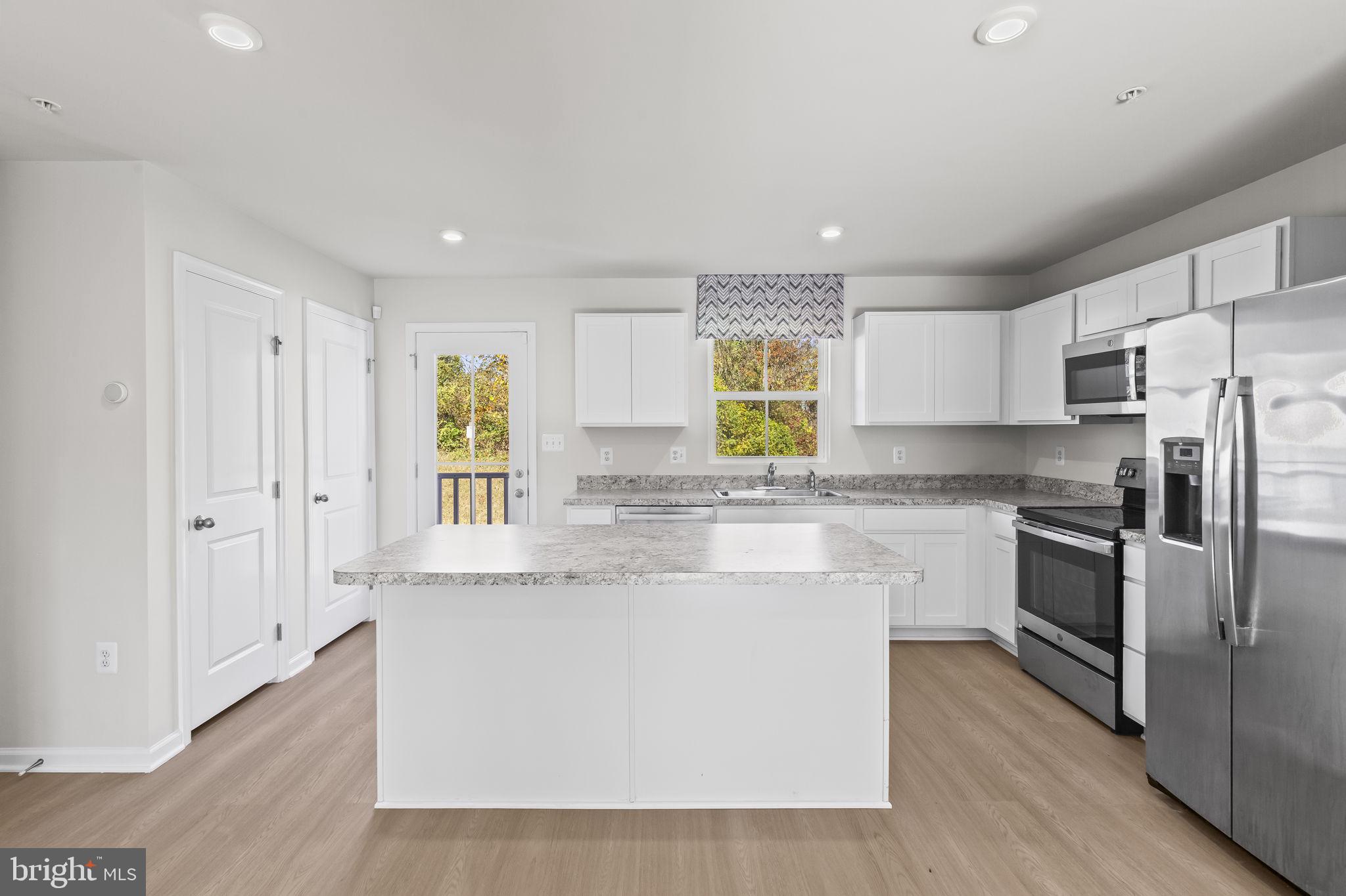 5404 Vergo Road Capitol Heights, MD 20743 - Photo 6 of 36 a large kitchen with stainless steel appliances granite countertop a stove a sink and a refrigerator