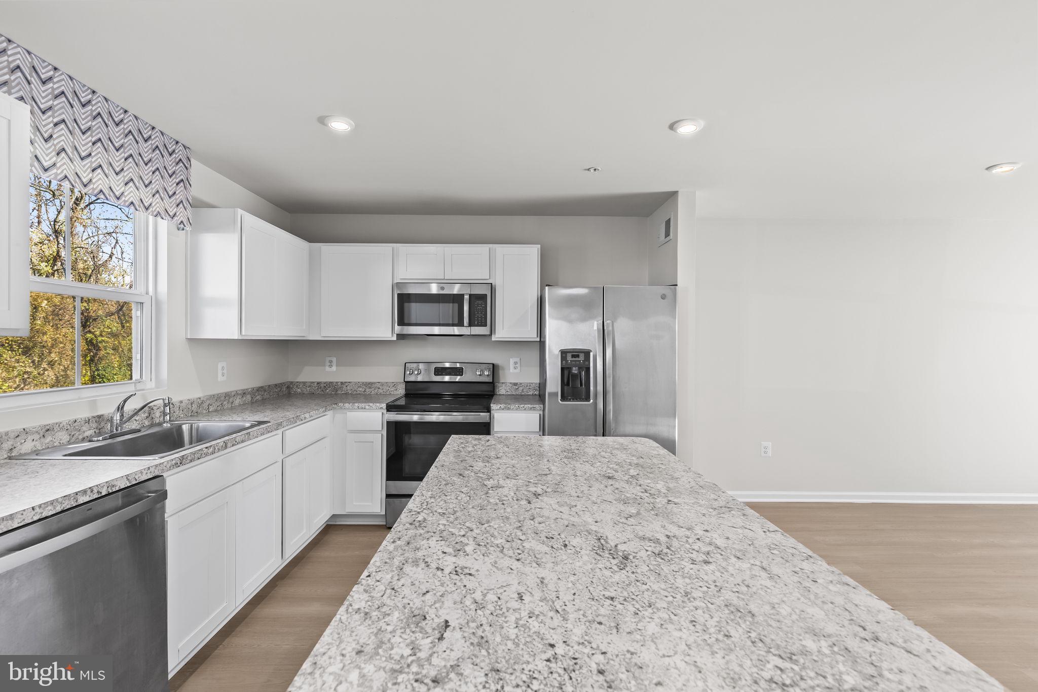 5404 Vergo Road Capitol Heights, MD 20743 - Photo 7 of 36 a kitchen with stainless steel appliances granite countertop a sink and cabinets