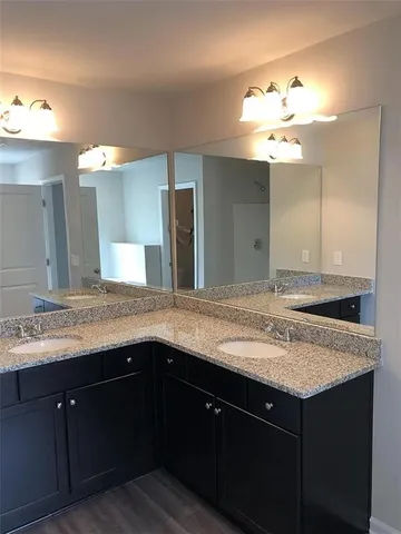 a bathroom with a granite countertop sink and a large mirror