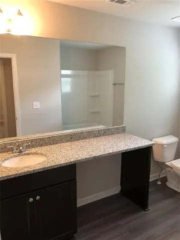 a room with granite countertop a sink and a wooden floor