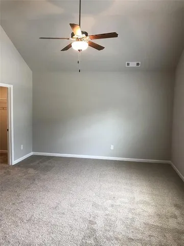 an empty room with a chandelier fan