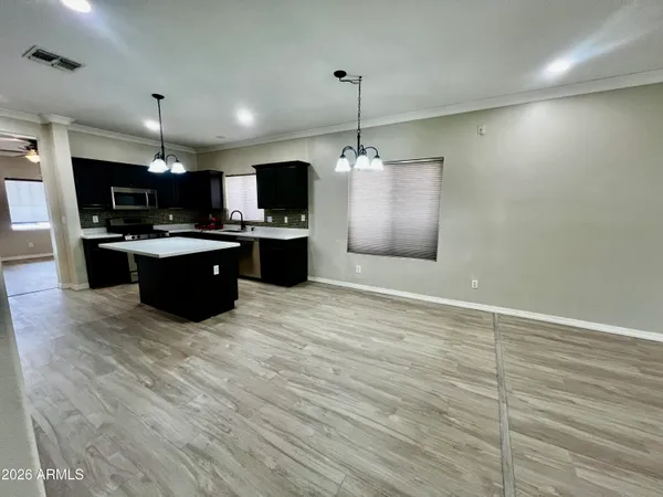 a large kitchen with kitchen island a stove a sink dishwasher a refrigerator and a flat screen tv