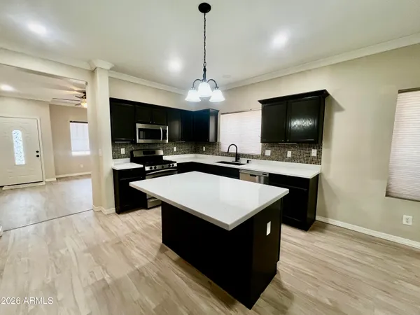 a large kitchen with stainless steel appliances a stove a sink dishwasher a fireplace with a dining table and chairs with wooden floor