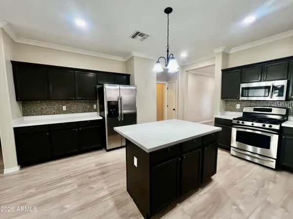 a kitchen with a stove a refrigerator and a microwave