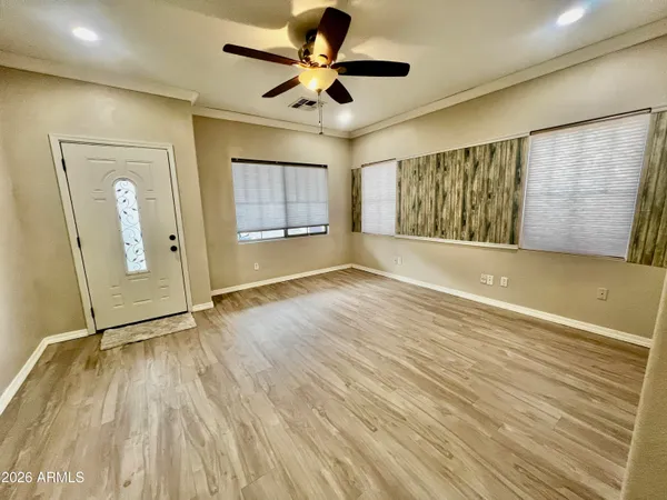 a view of an empty room with a window and wooden floor
