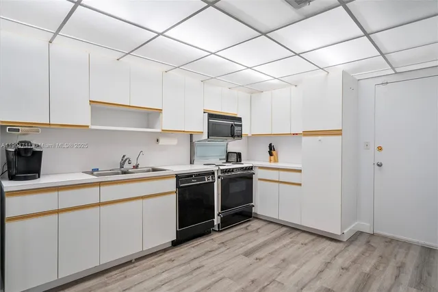 a kitchen with a sink a stove and cabinets