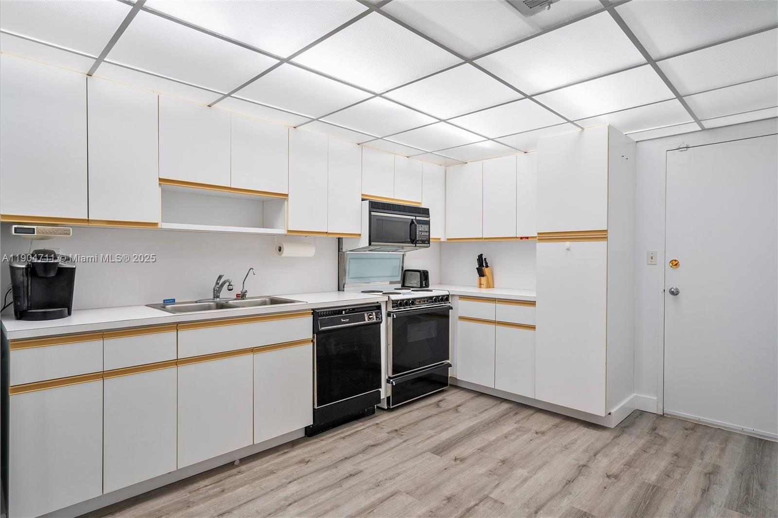 5001 Collins Avenue, Unit 11F Miami Beach, FL 33140 - Photo 11 of 43 a kitchen with a sink cabinets and stainless steel appliances