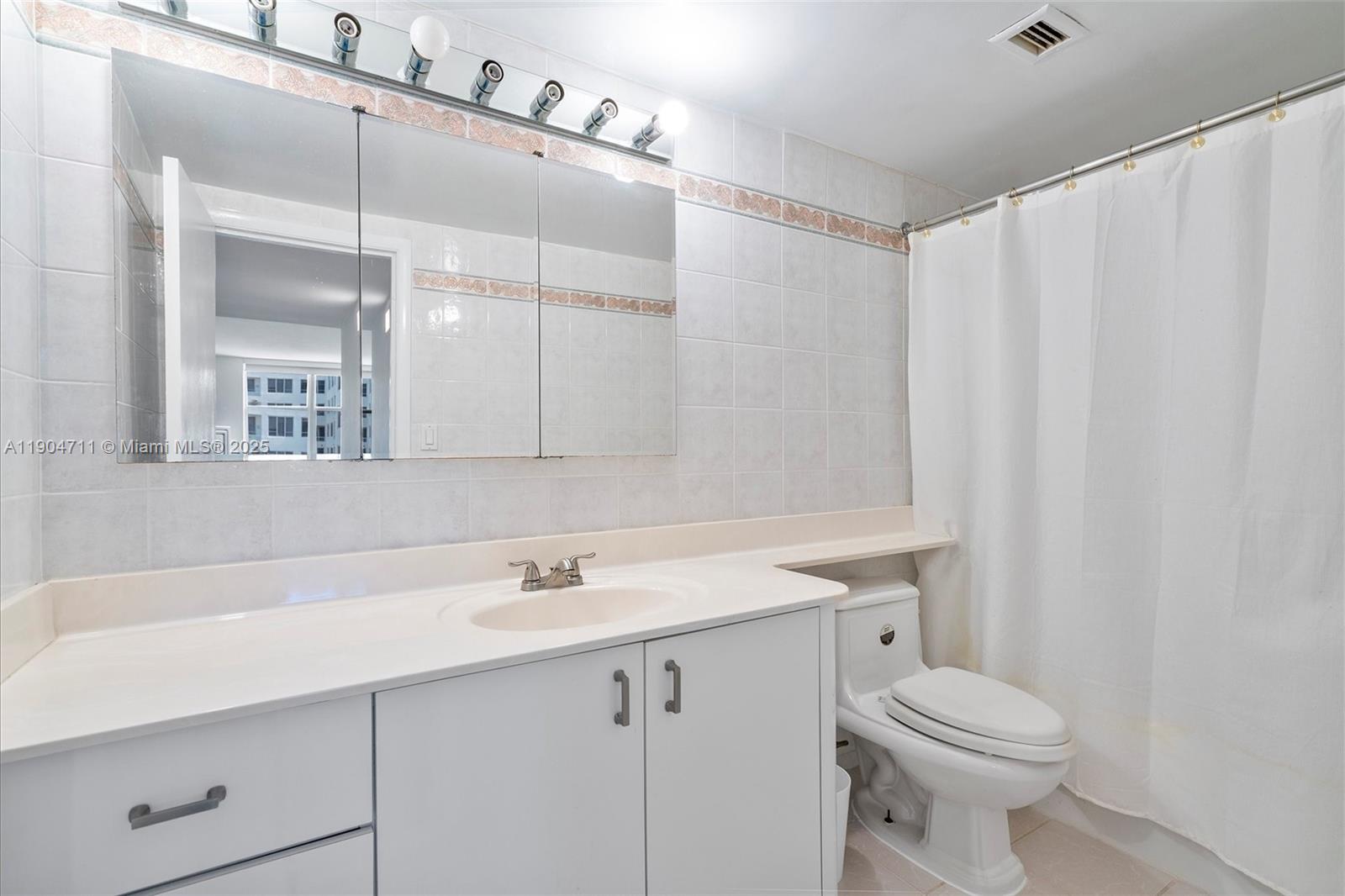 5001 Collins Avenue, Unit 11F Miami Beach, FL 33140 - Photo 21 of 43 a bathroom with a sink a toilet and vanity