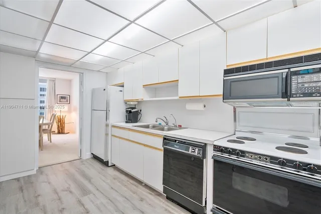 a kitchen with a sink a stove and cabinets