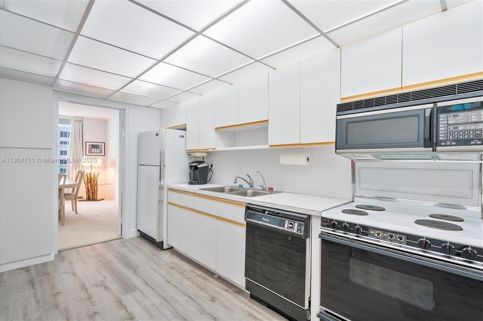 5001 Collins Avenue, Unit 11F Miami Beach, FL 33140 - Photo 9 of 43 a kitchen with stainless steel appliances granite countertop a stove and a refrigerator