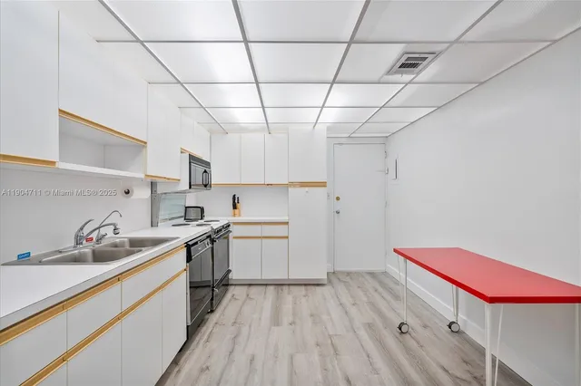 a kitchen with a sink cabinets and stainless steel appliances