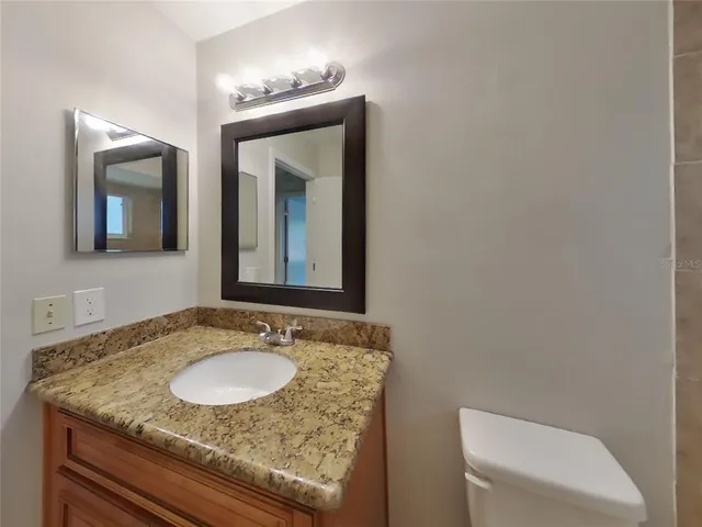 a bathroom with a granite countertop sink and a mirror