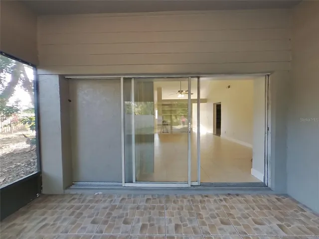 a view of empty room with wooden floor and a window