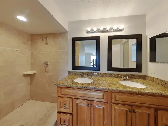 a bathroom with a granite countertop sink and a mirror