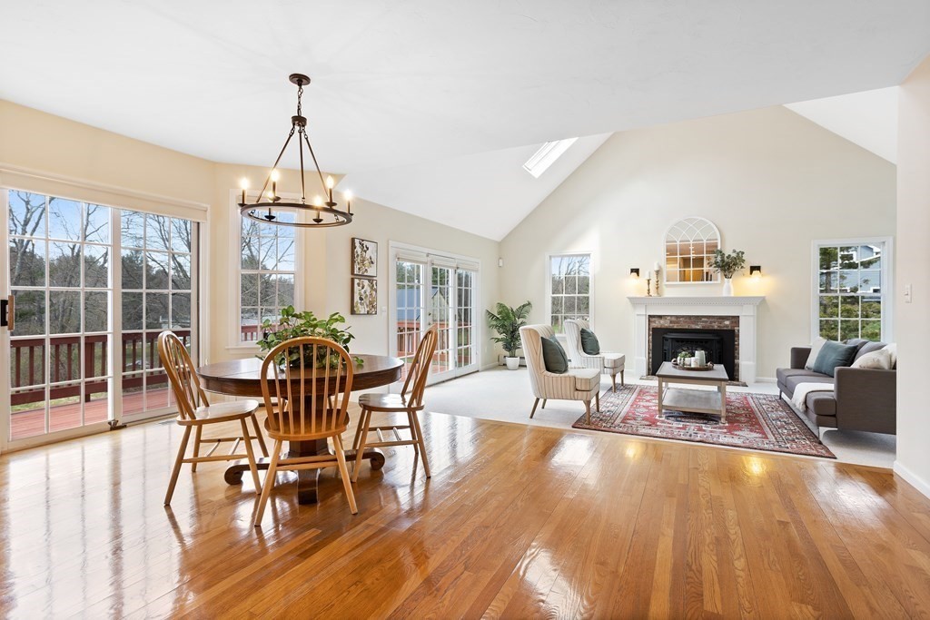 104 Nourse Road Bolton, MA 01740 - Photo 11 of 34 a living room with furniture a fireplace and a dining table with wooden floor