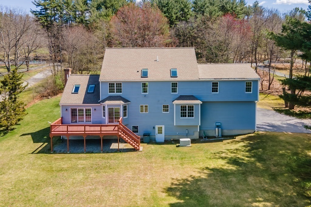 104 Nourse Road Bolton, MA 01740 - Photo 30 of 34 an aerial view of a house with swimming pool and large trees