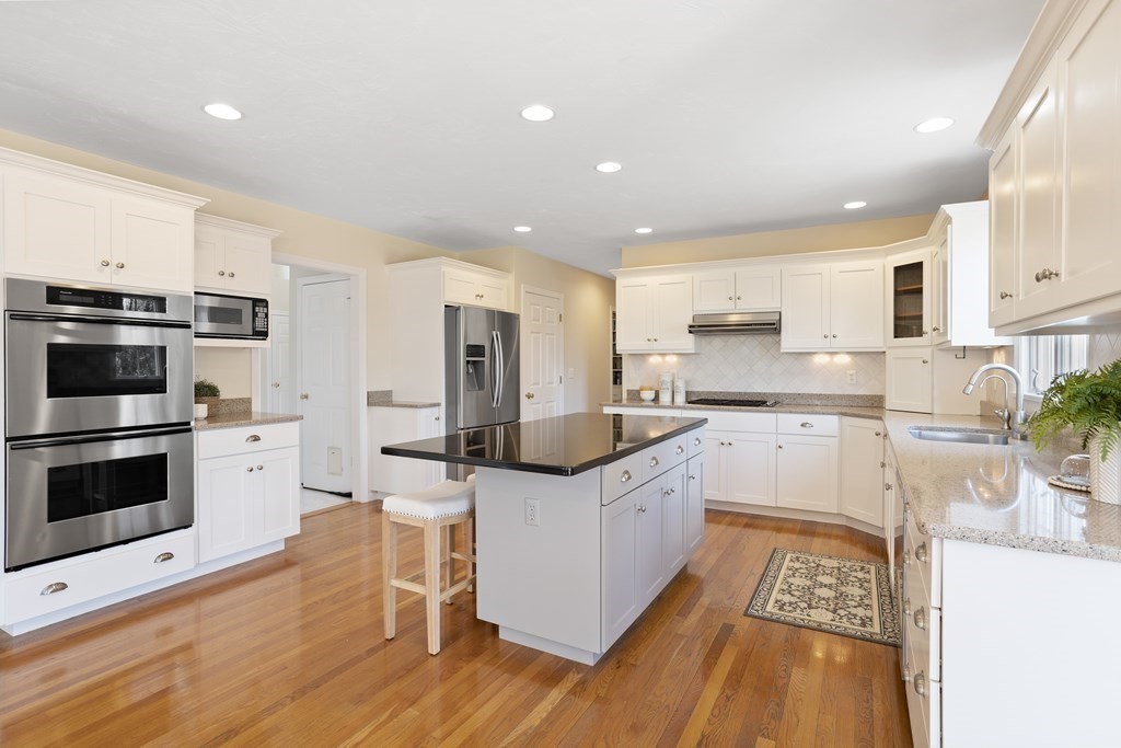 104 Nourse Road Bolton, MA 01740 - Photo 6 of 34 a kitchen with stainless steel appliances kitchen island granite countertop a stove top oven a sink a counter top space and cabinets