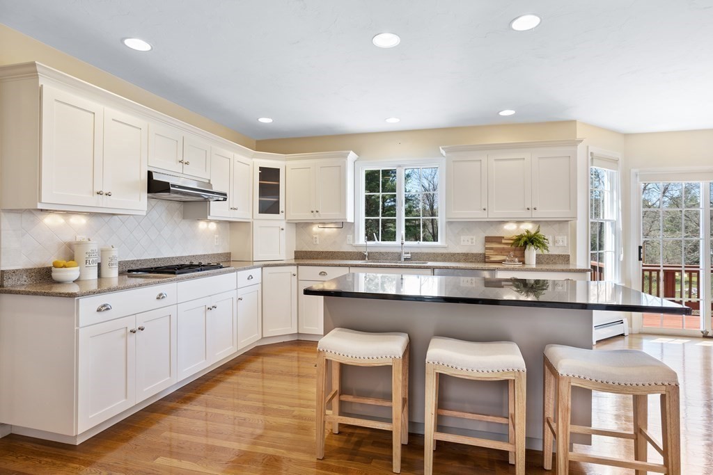 104 Nourse Road Bolton, MA 01740 - Photo 7 of 34 a kitchen with granite countertop white cabinets and chairs