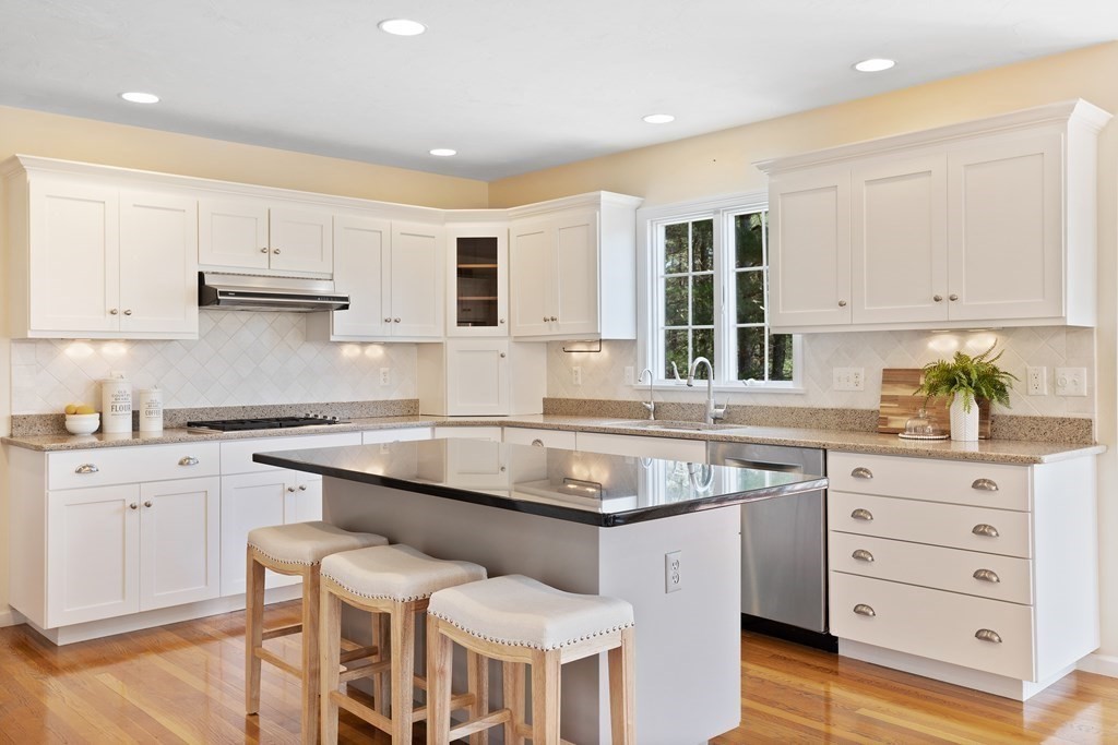 104 Nourse Road Bolton, MA 01740 - Photo 8 of 34 a kitchen with granite countertop white cabinets and white appliances