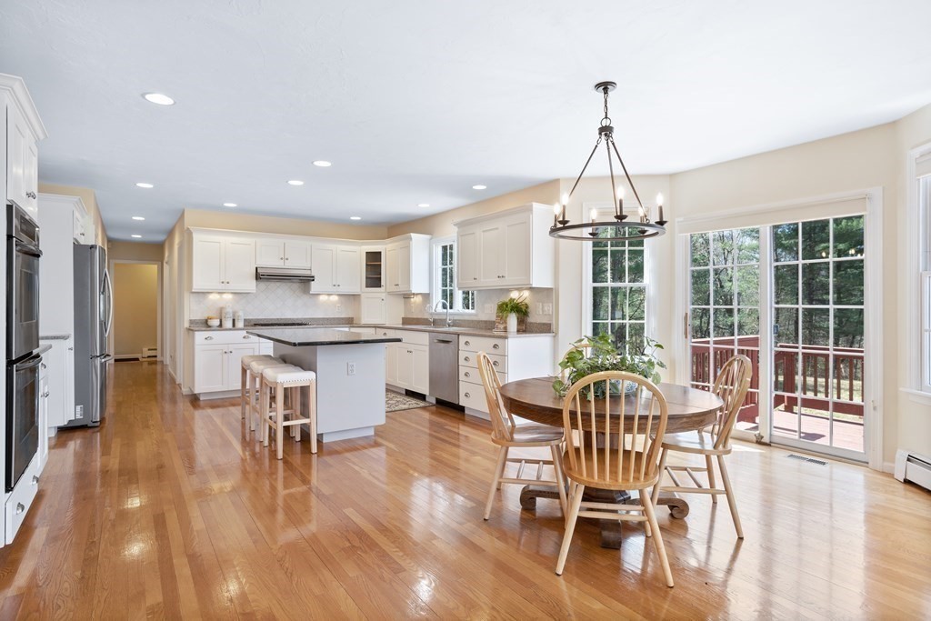 104 Nourse Road Bolton, MA 01740 - Photo 9 of 34 a dining room with furniture a chandelier and wooden floor