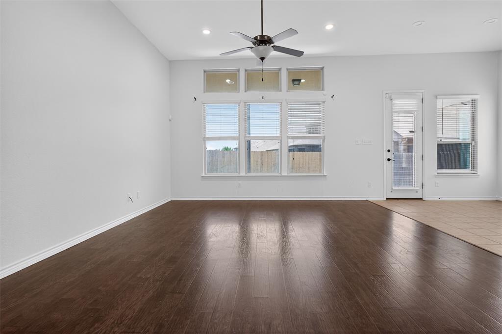 8728 Maple Ridge Trail Fort Worth, TX 76244 - Photo 13 of 40 Spacious interior room featuring high ceilings, dark wood-finish flooring, and ample natural light from multiple windows