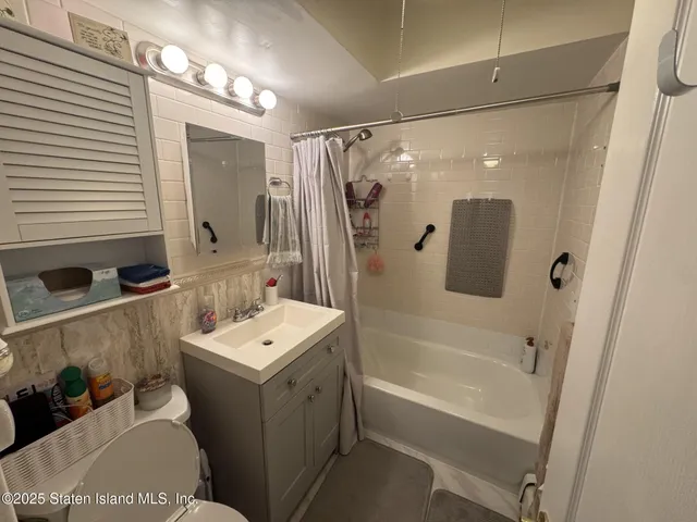 a bathroom with a tub sink and mirror
