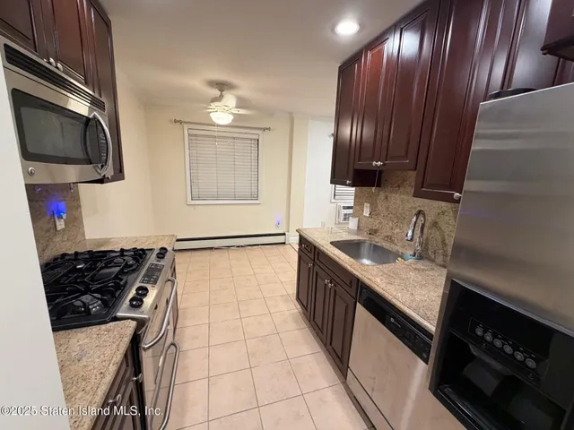 a kitchen with granite countertop stainless steel appliances a sink stove top oven and cabinets
