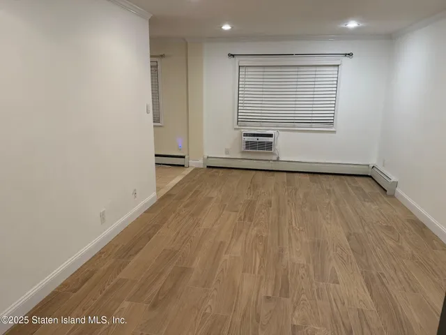 a view of a room with wooden floor and window