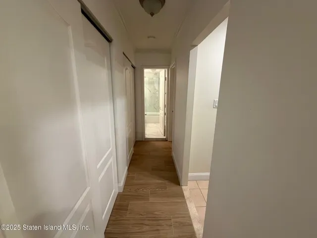 a view of a hallway with wooden floor and staircase