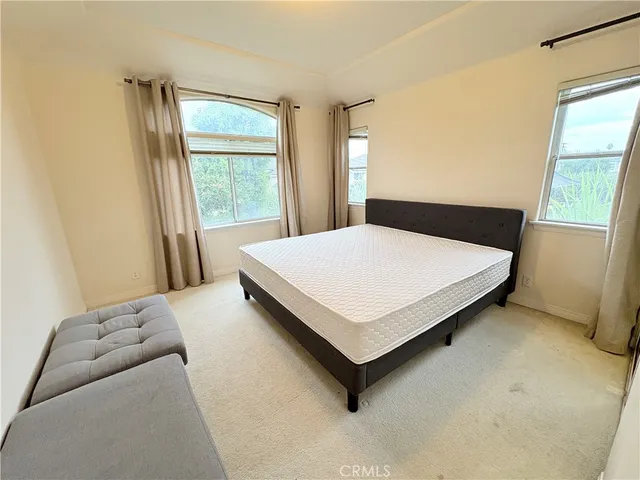 a bed sitting in a bedroom next to a window