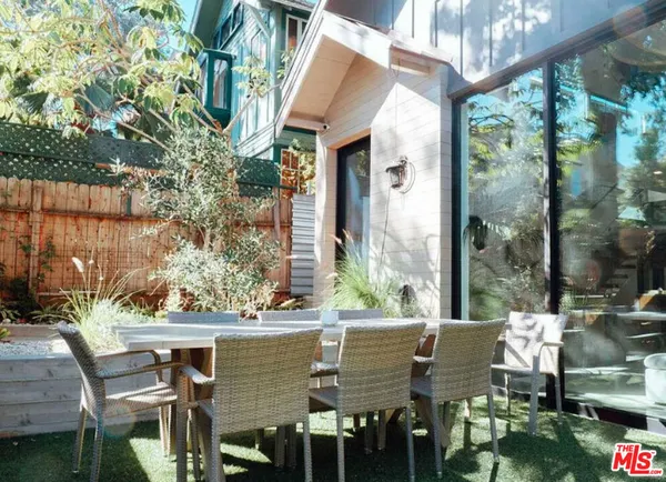 a view of an outdoor dining space with a table and chairs