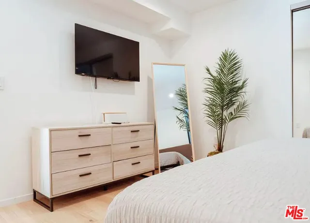 a bedroom with a bed and a flat screen tv