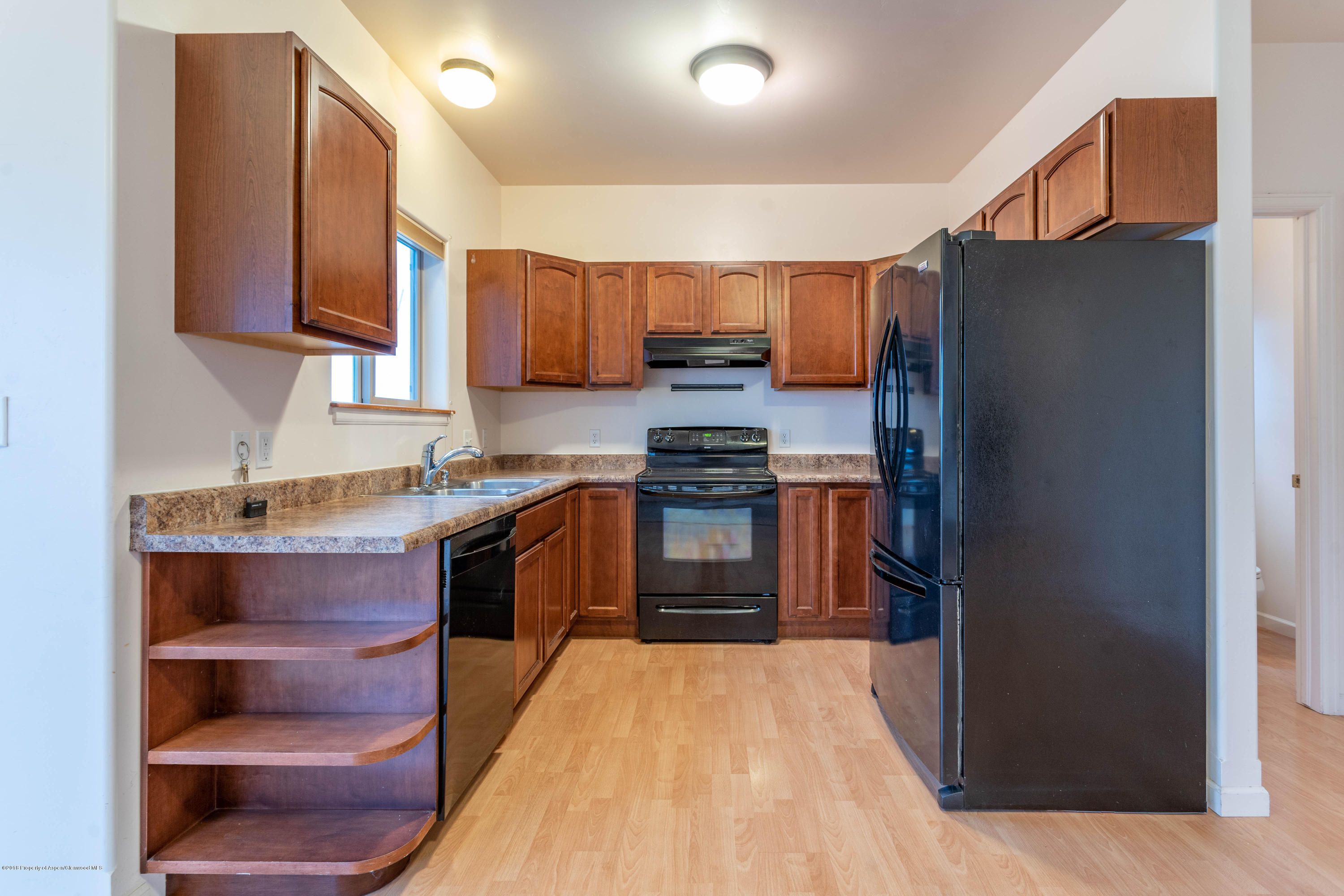 953 East 17th Street Rifle, CO 81650 - Photo 3 of 15 a kitchen with stainless steel appliances granite countertop a refrigerator a stove and a sink with wooden cabinets