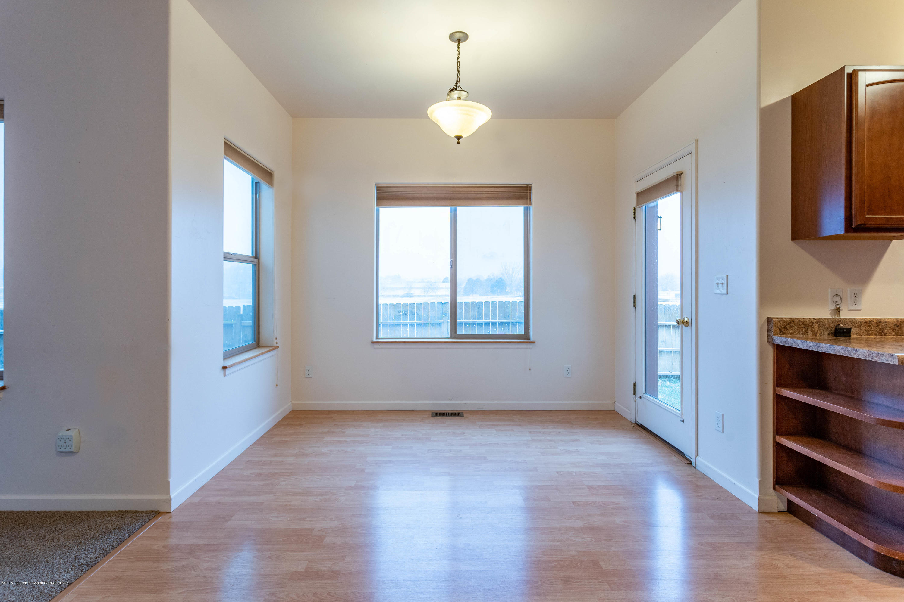 953 East 17th Street Rifle, CO 81650 - Photo 4 of 15 an empty room with wooden floor cabinet and windows