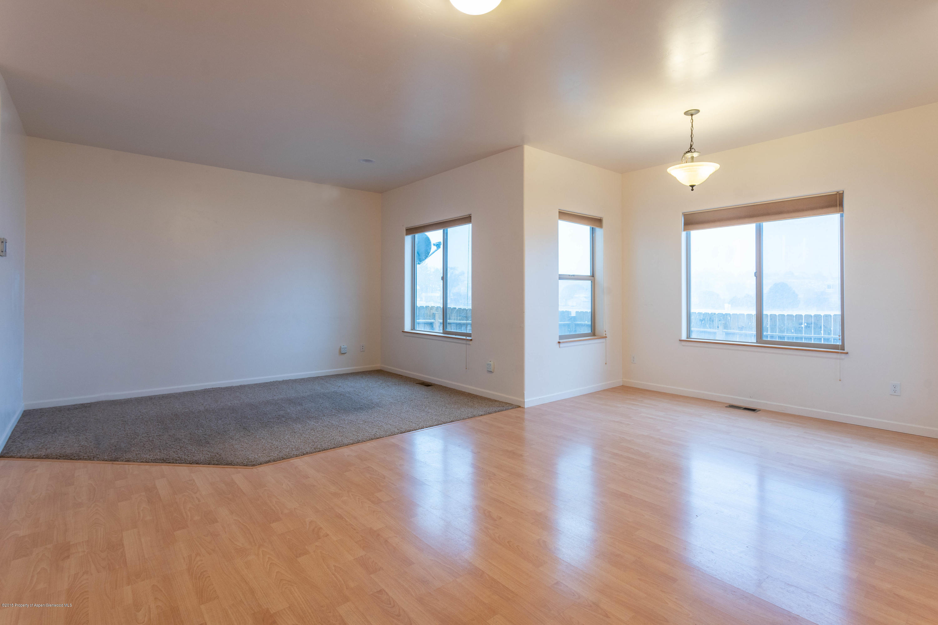 953 East 17th Street Rifle, CO 81650 - Photo 5 of 15 an empty room with wooden floor and windows