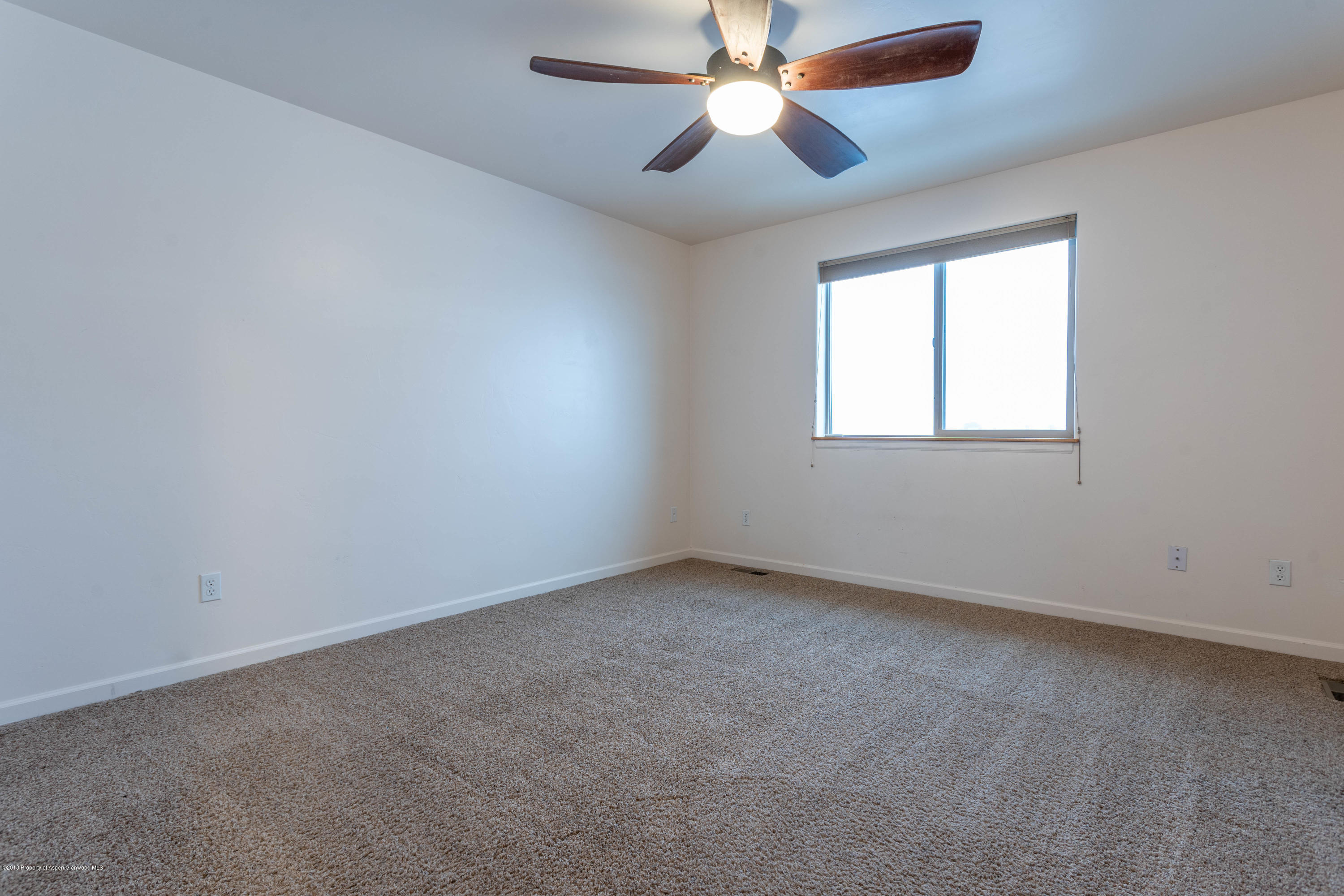 953 East 17th Street Rifle, CO 81650 - Photo 8 of 15 an empty room with a window and a fan