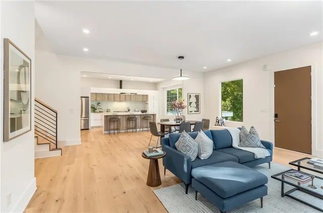 a kitchen with stainless steel appliances a dining table chairs and wooden floor