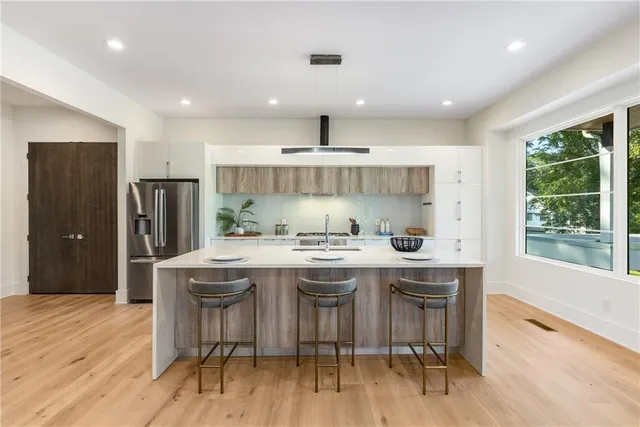 a kitchen with stainless steel appliances granite countertop a stove and a wooden floors