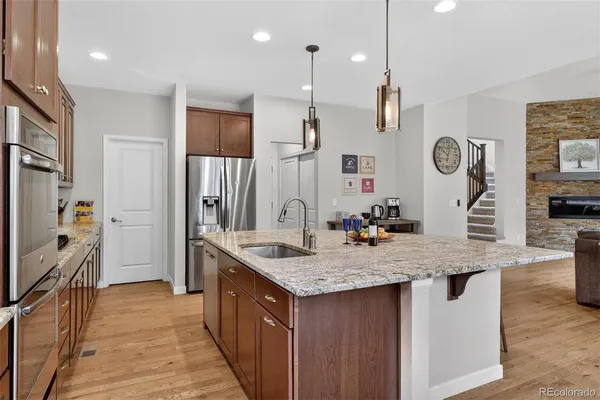 a kitchen with stainless steel appliances granite countertop a sink stove and refrigerator