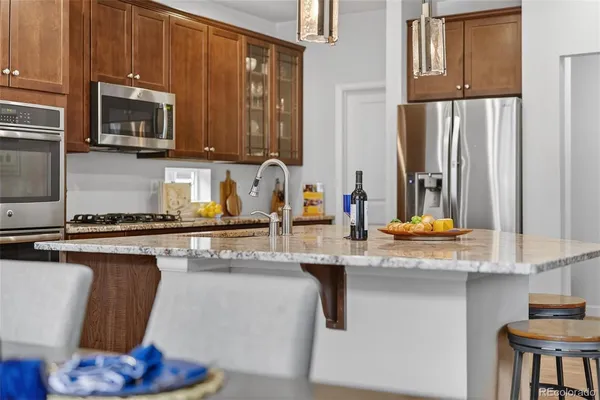 a kitchen with stainless steel appliances granite countertop a sink a stove and a microwave
