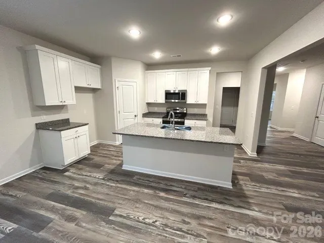 a large kitchen with kitchen island a sink stainless steel appliances and cabinets