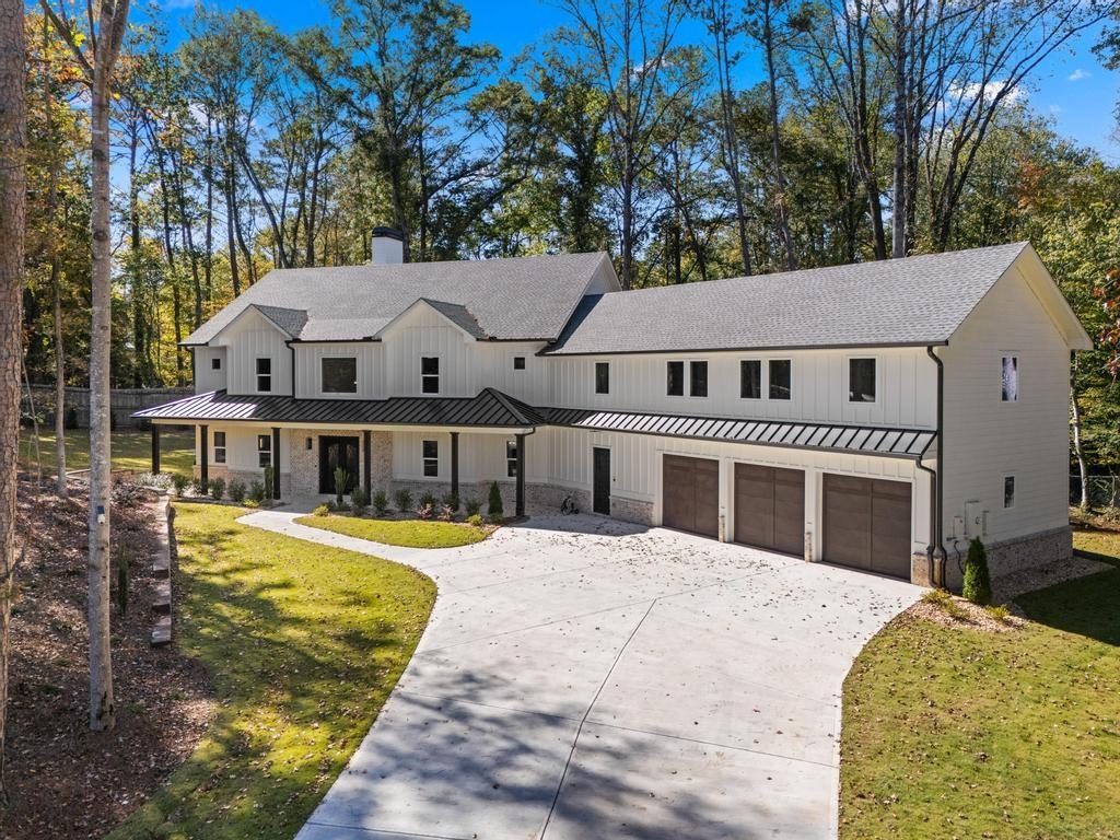 4611 Medlock Bridge Road Peachtree Corners, GA 30097 - Photo 1 of 36 a front view of a house with a yard table and chairs