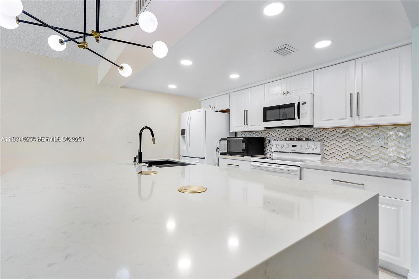1281 West Fairway Road Pembroke Pines, FL 33026 - Photo 12 of 29 a kitchen with sink a stove and cabinets