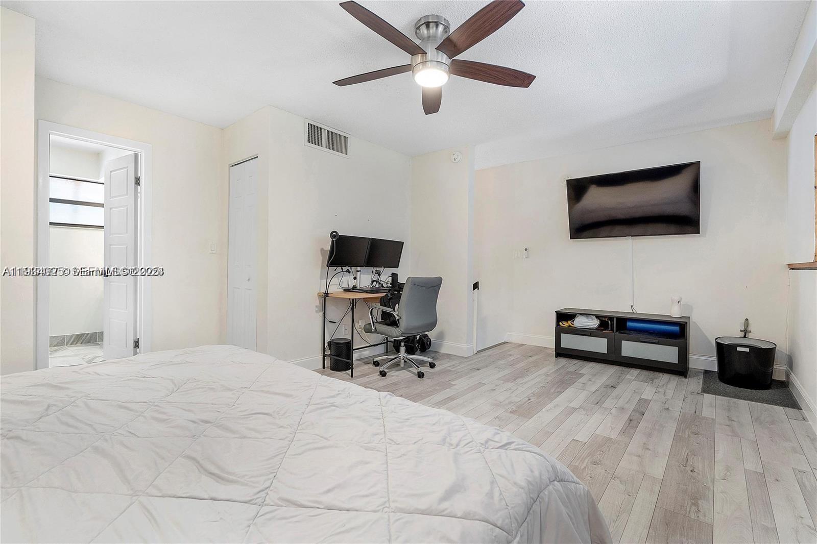 1281 West Fairway Road Pembroke Pines, FL 33026 - Photo 19 of 29 a bedroom with a bed a flat screen tv and a couch