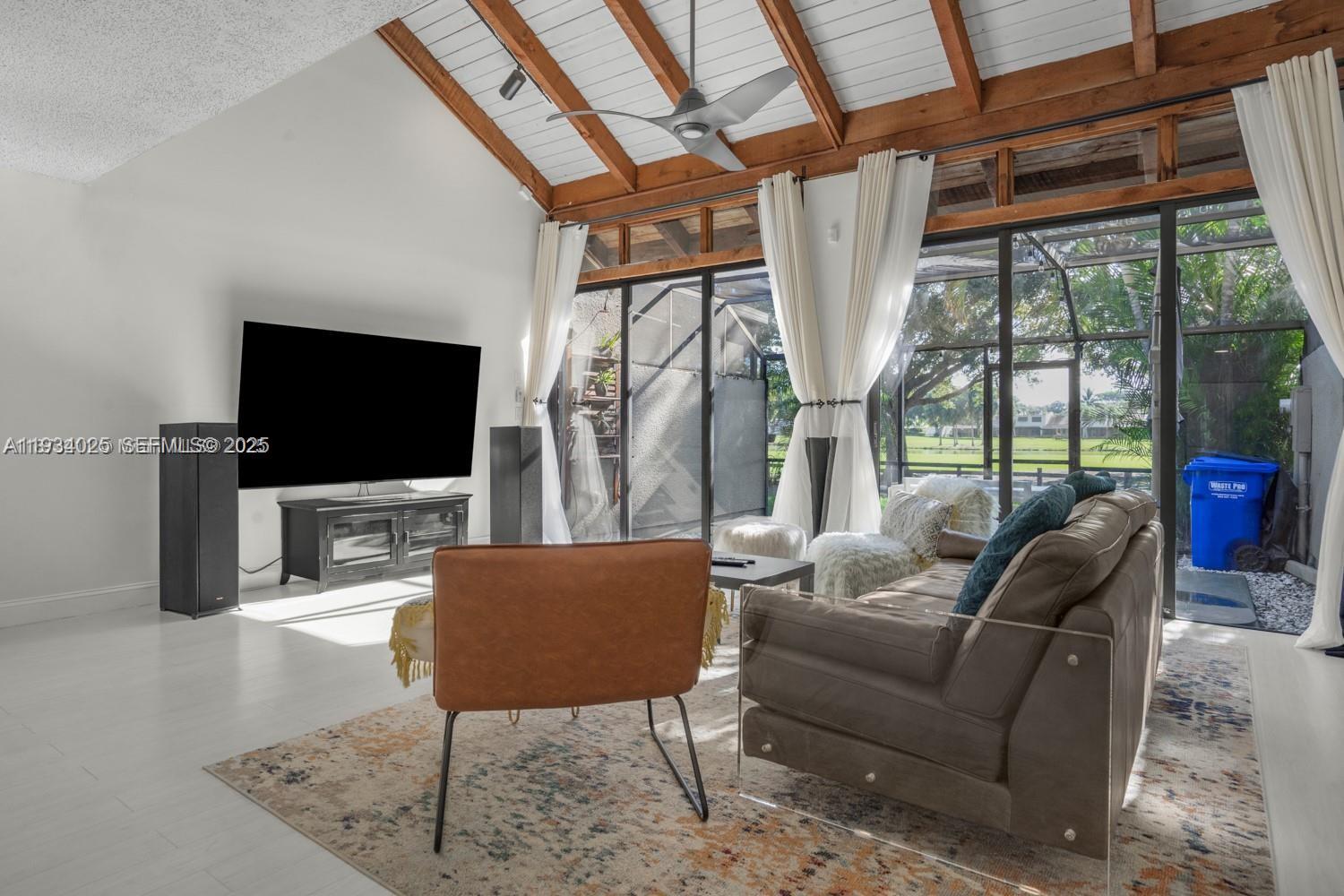 1281 West Fairway Road Pembroke Pines, FL 33026 - Photo 24 of 29 a living room with furniture a flat screen tv and a floor to ceiling window