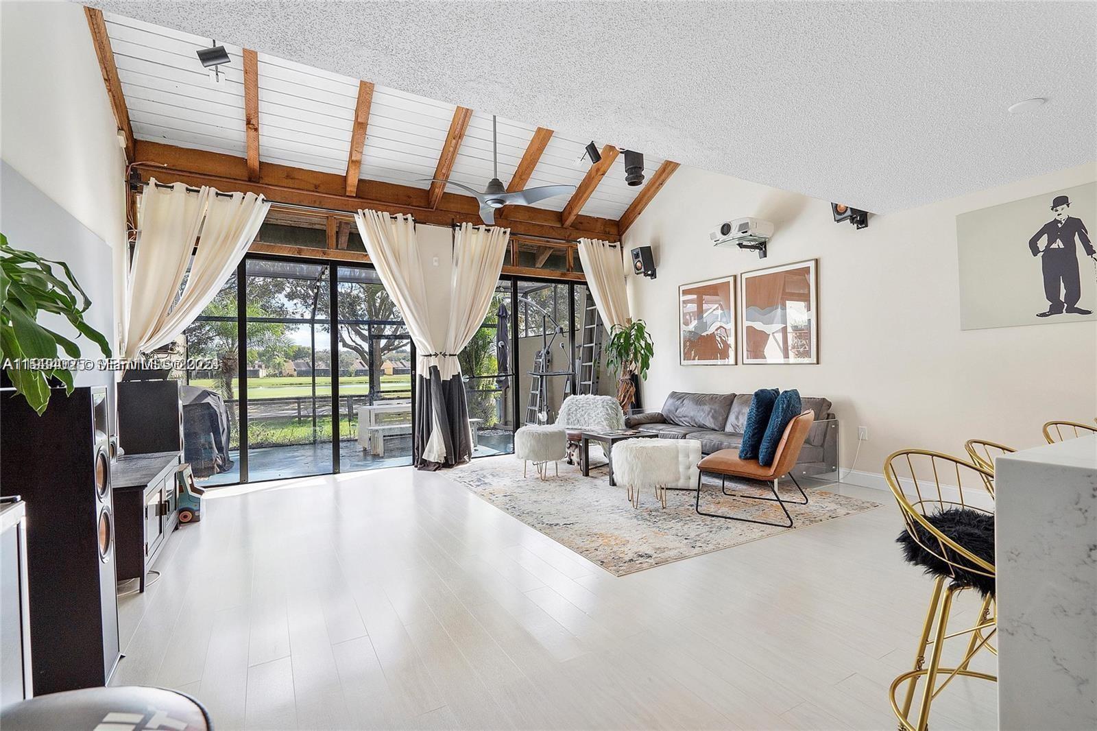 1281 West Fairway Road Pembroke Pines, FL 33026 - Photo 7 of 29 a living room with furniture a flat screen tv and a floor to ceiling window